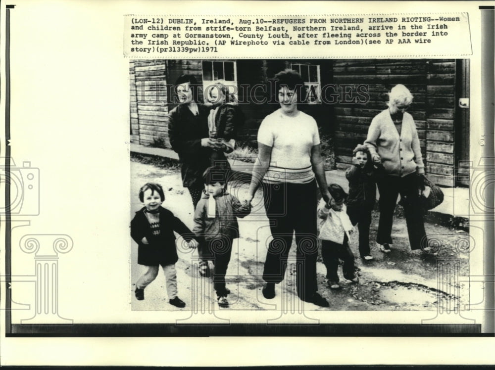 1971 Women, children walk in street to Irish army camp, Gormanstown - Historic Images