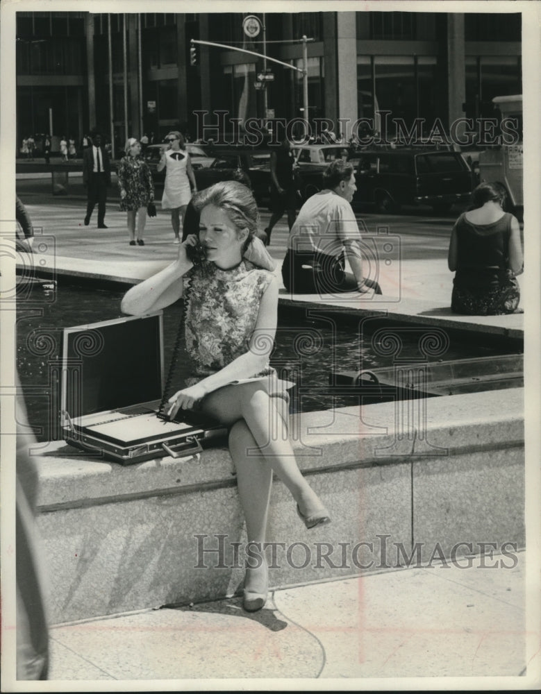 1967 Press Photo A girl uses a portable executive telephone in New York City. - Historic Images