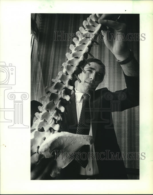 1983 Frank Fantazzi holds a model of the human spine - Historic Images