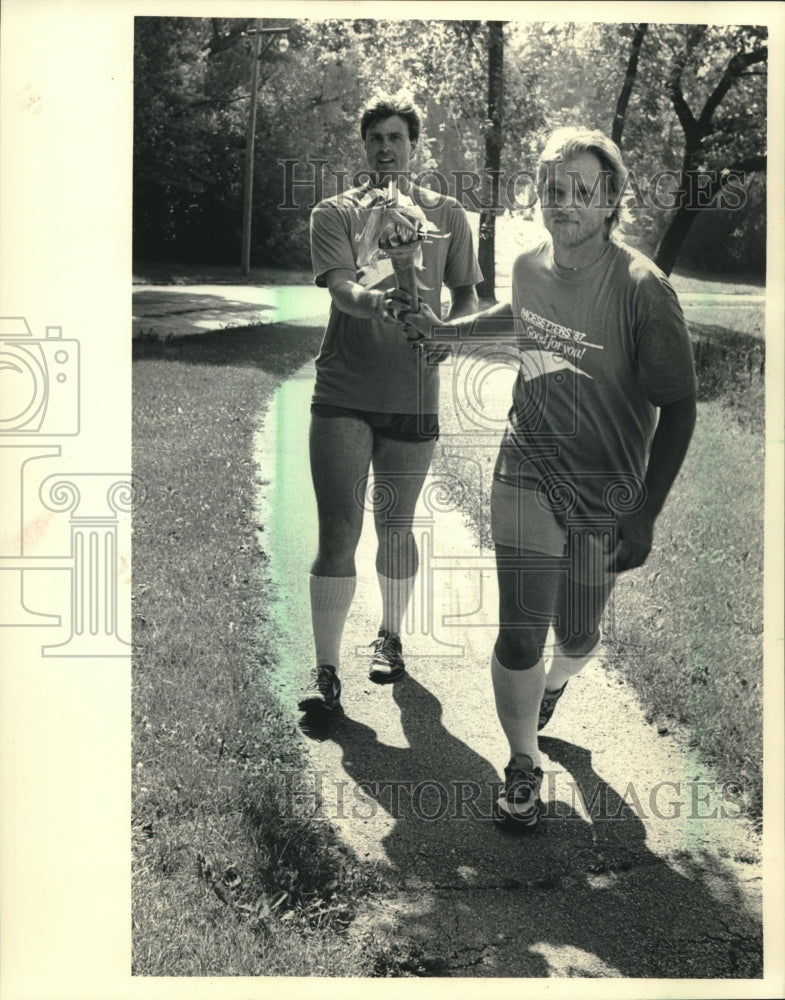 1987 runner pass torch for Milwaukee United Way fund drive - Historic Images