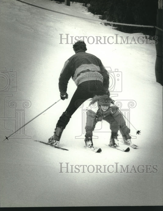 1995 Press Photo Emily Piontek of Slinger, skis between the legs of her father - Historic Images
