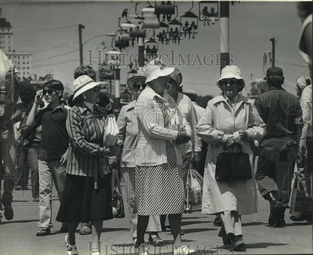 1980 Press Photo Older ladies walk under people on ski lift at Summerfest - Historic Images