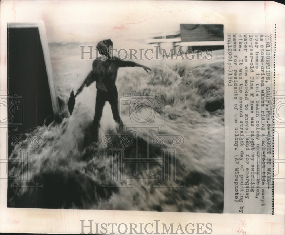 1963, Tina Rowe caught by storm water while shoveling near Long Beach - Historic Images