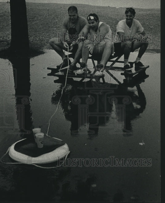 1991, Rain floods Summerfest, three men's inventive way to get drinks - Historic Images