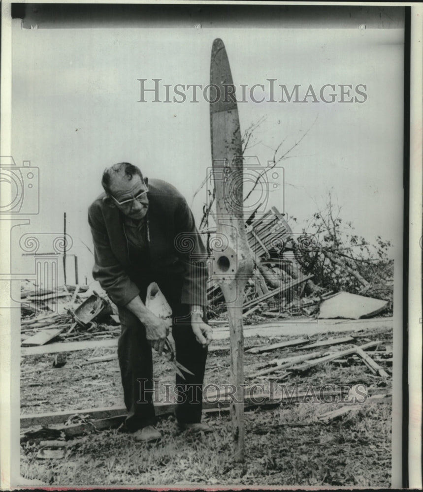 1966, Joe Humerick inspects airplane propeller in yard after storm - Historic Images