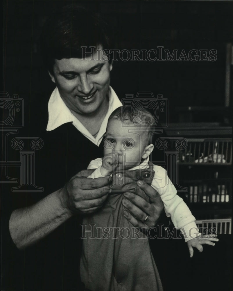 1986 John M. Hart of Milwaukee holds his son, Christopher - Historic Images