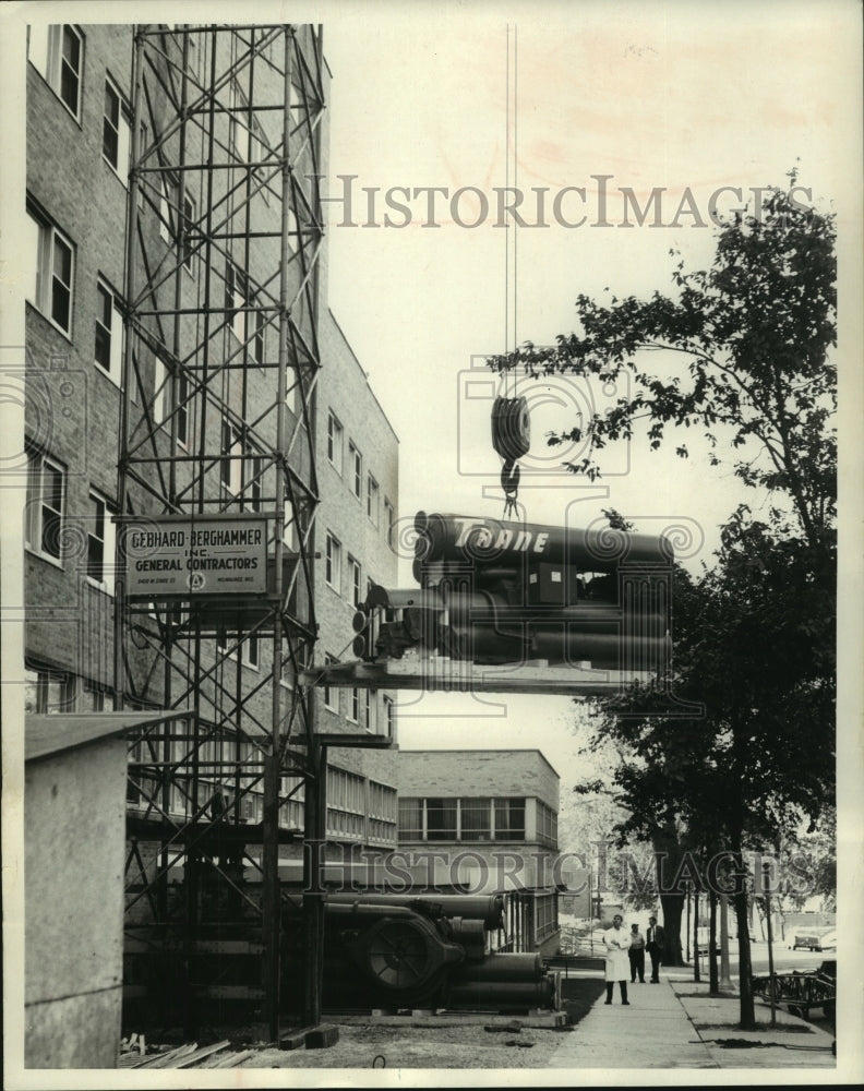 1965, Air conditioning units hoisted onto Deaconess hospital roof - Historic Images