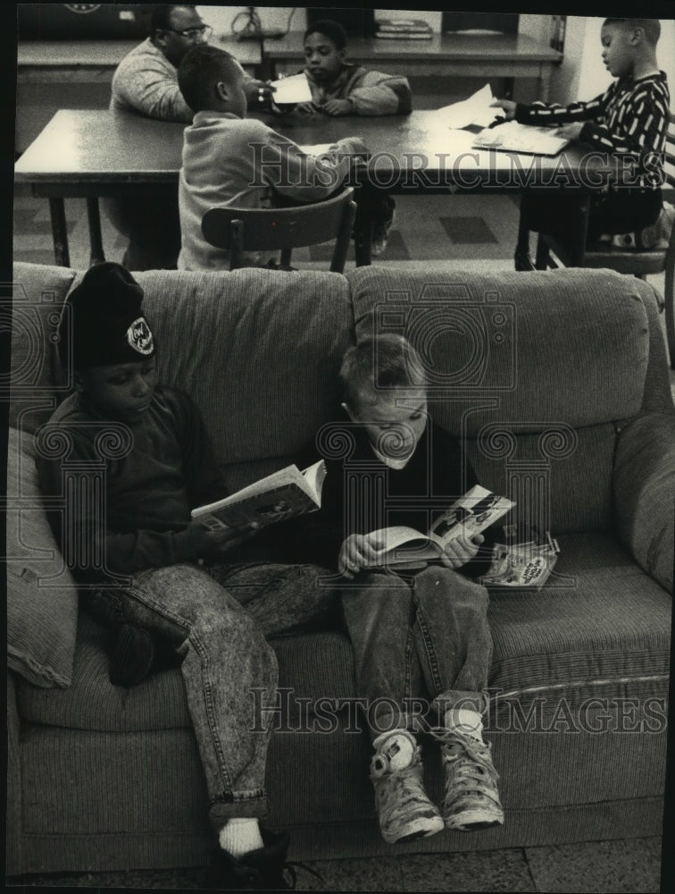 1993, Lavelle Monroe and Chris Reff Read on Couch at Taylor Home - Historic Images