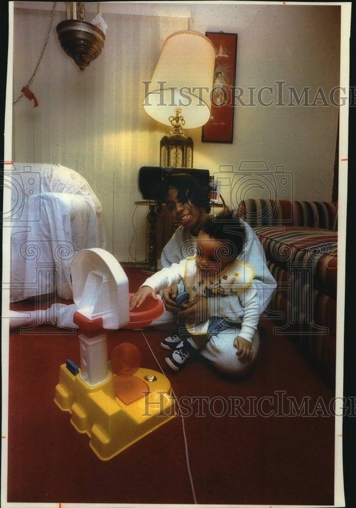 1994 Tamara Crawford, 17, plays with her 1-year-old son Quincy. - Historic Images