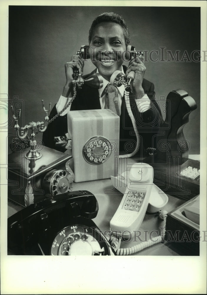 1983, Woman holds phones from PhoneCenter store in Milwaukee - Historic Images
