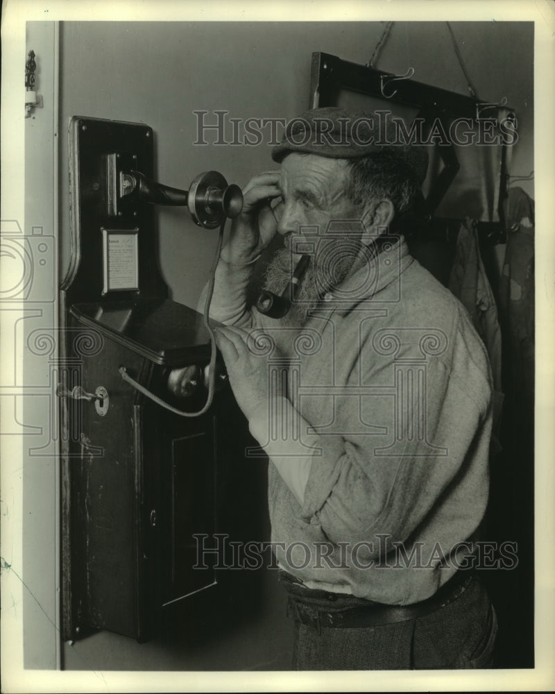 1969 Press Photo Man with pipe talks on old telephone - mjc06536 - Historic Images