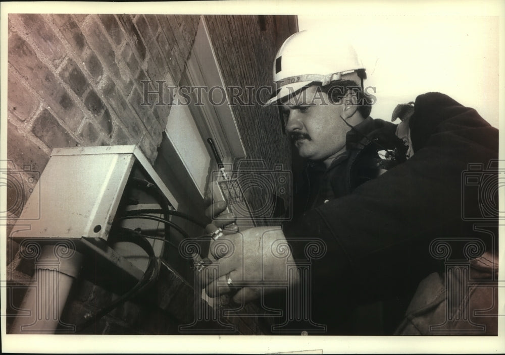 1993 Press Photo Joel Moths checks a cable box on a Milwaukee duplex for pirates - Historic Images