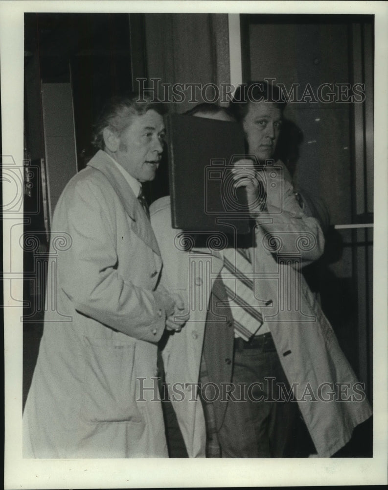 1975 Press Photo Mayor Maier's face covered by his bodyguard entering party - Historic Images