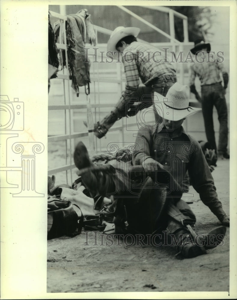 1982 Mike Steiger stretches before competing at Holmes Rodeo - Historic Images