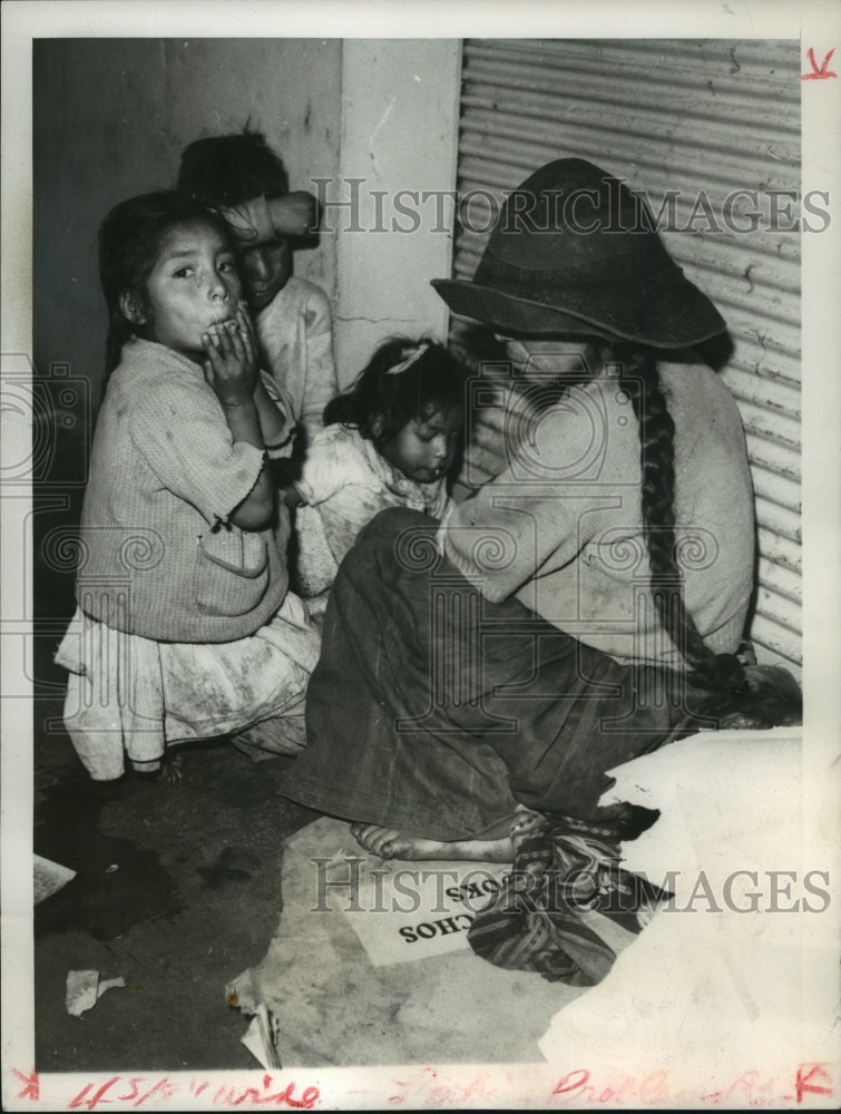 1962 Press Photo Homeless family in Lima, Peru huddles against a wall downtown - Historic Images