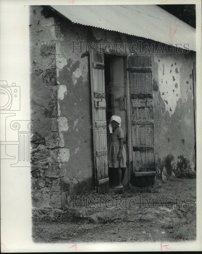 1974, Woman stands by barn doors on Seychelles Islands - mjc07421 - Historic Images