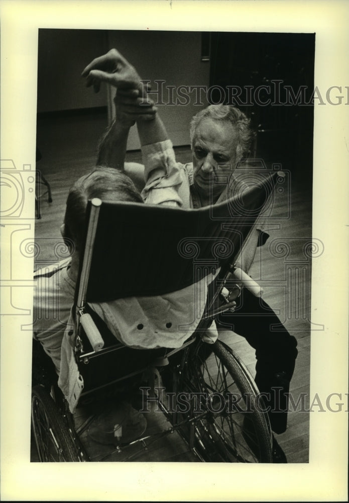 1981, Christ T. Seraphim helped patient exercise at VA hospital - Historic Images