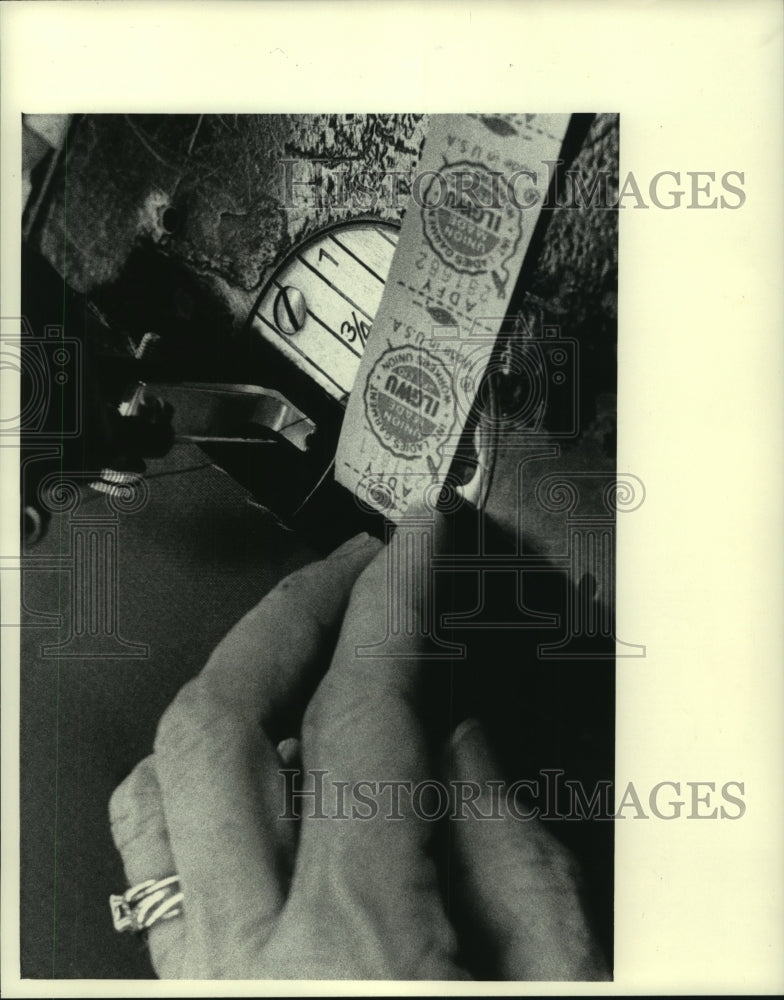 1983 Press Photo Sewing on the label is sewing machine operator's final chore - Historic Images