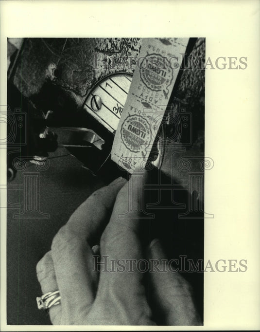 1983 Press Photo Sewing on the label is sewing machine operator's final chore - Historic Images