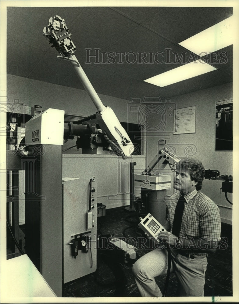 1986 Press Photo Robert Castelli of Milwaukee Robotics demonstrates robot - Historic Images