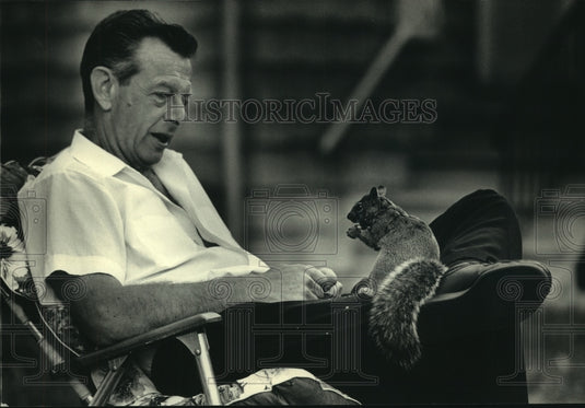 1987 Press Photo Walter Smith feeding squirrel at his Bay View home Wisconsin - Historic Images