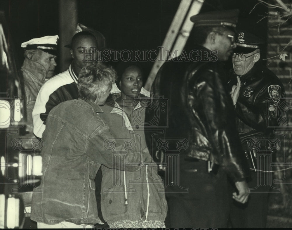 1993 Press Photo Reta Allen restrained by neighbor as police work at house fire. - Historic Images