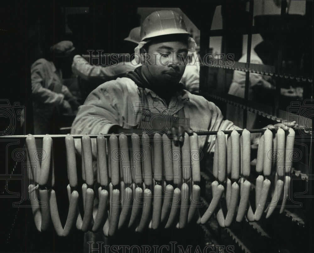 1990 Press Photo Rod Hammond of Usinger's hangs brats on sausage rack Wisconsin - Historic Images