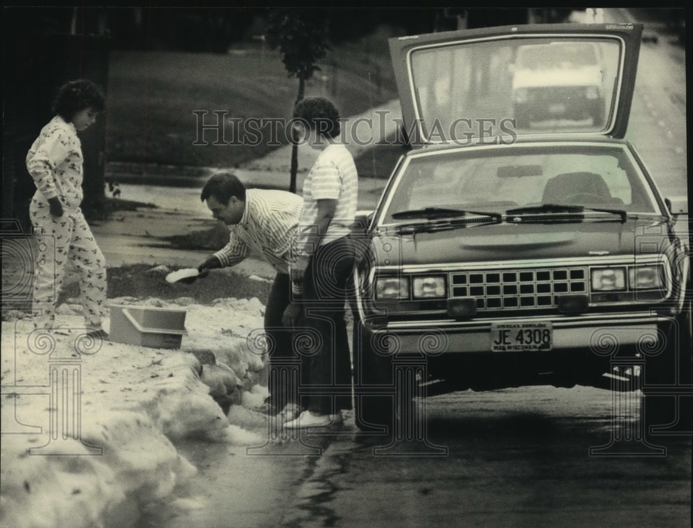1988, Melk family scoops up summer hail in Milwaukee, Wisconsin - Historic Images