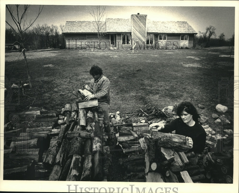 1988 Press Photo The Kuszs Stack Firewood from Trees Downed in Tornado - Historic Images