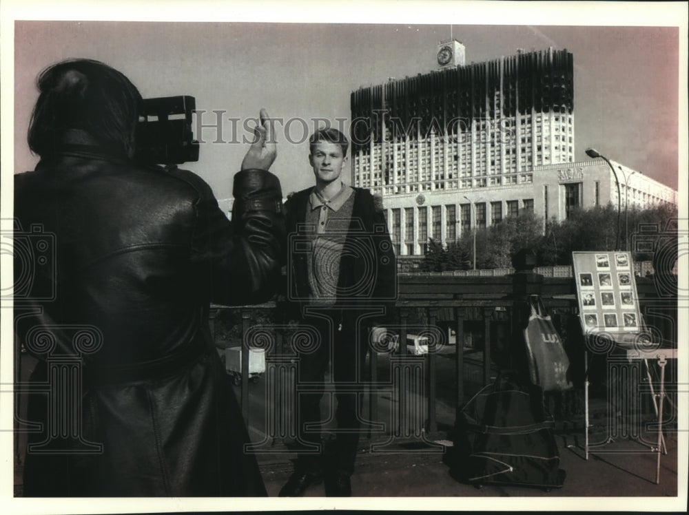 1993 Press Photo Tourist in front of charred Russian Parliament building, Russia - Historic Images