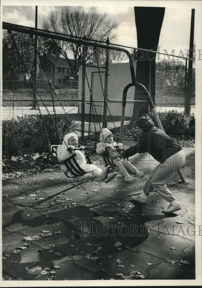 1988 Press Photo Karen Bulgerin pushes children on swings in Waukesha, WI - Historic Images