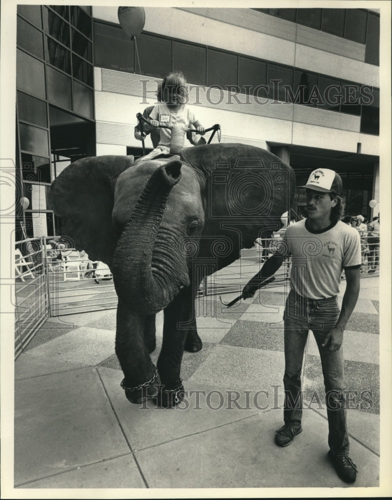 1988 Press Photo Child Riding Elephant at Plaza East on Tenant Appreciation Day - Historic Images