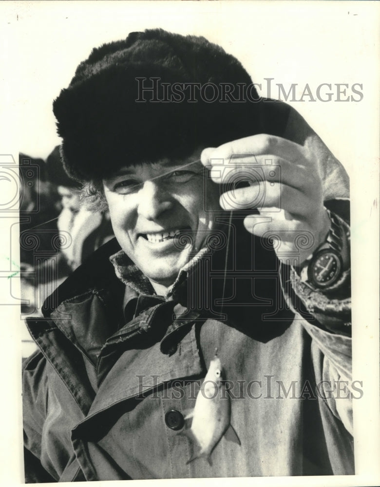 1984 Press Photo Russian fisherman holds a tiny fish after ice-fishing - Historic Images