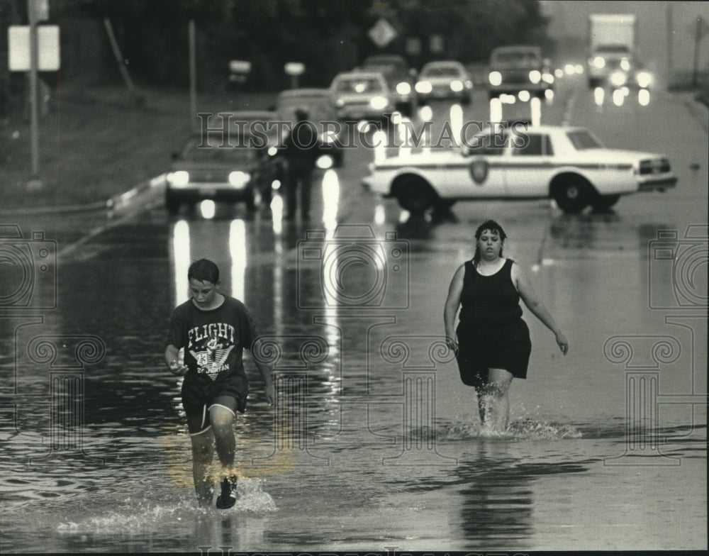 1991 Press Photo Christopher Devore and aunt Brenda walk thru flood water, WI - Historic Images