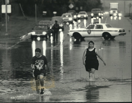 1991 Press Photo Christopher Devore and aunt Brenda walk thru flood water, WI - Historic Images