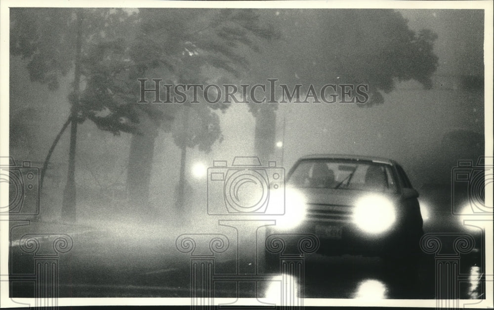 1991 Press Photo Cars drive thru storm near St. Joseph's Catholic Church, WI - Historic Images