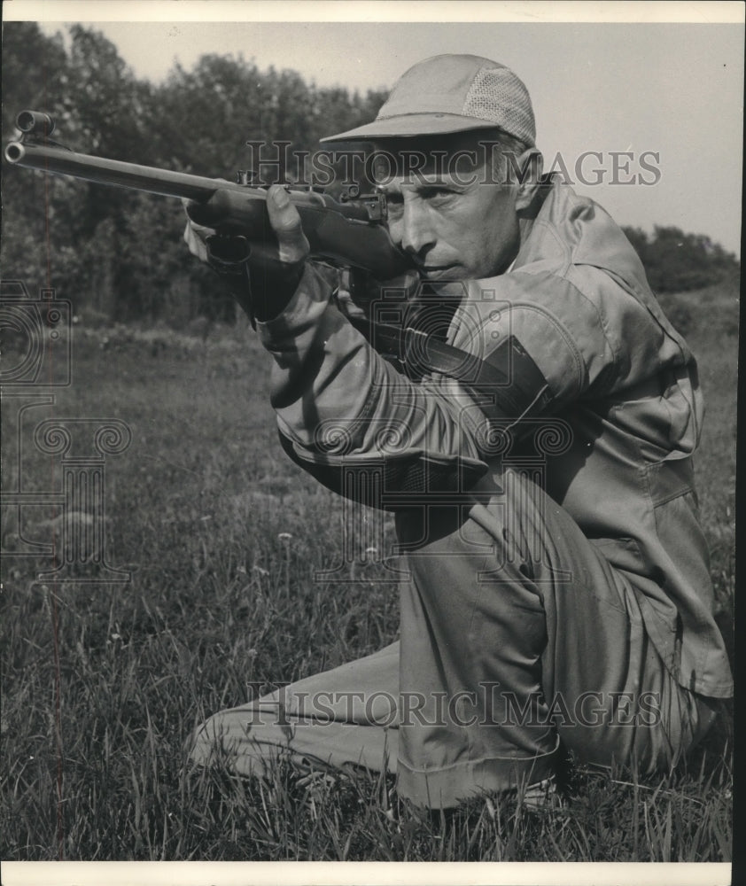 1954 Press Photo Sturm kneels, both eyes open, to prepare for a shot - mjc10068 - Historic Images