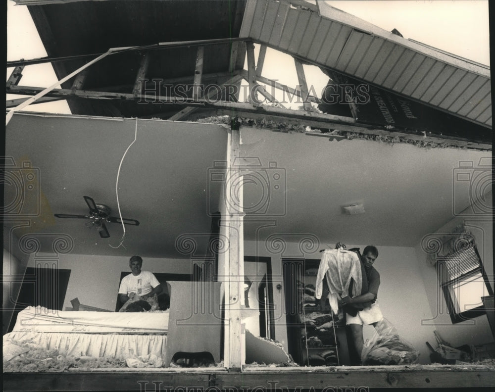 1992, Men pick up belongings after a tornado in Waubesa Heights - Historic Images
