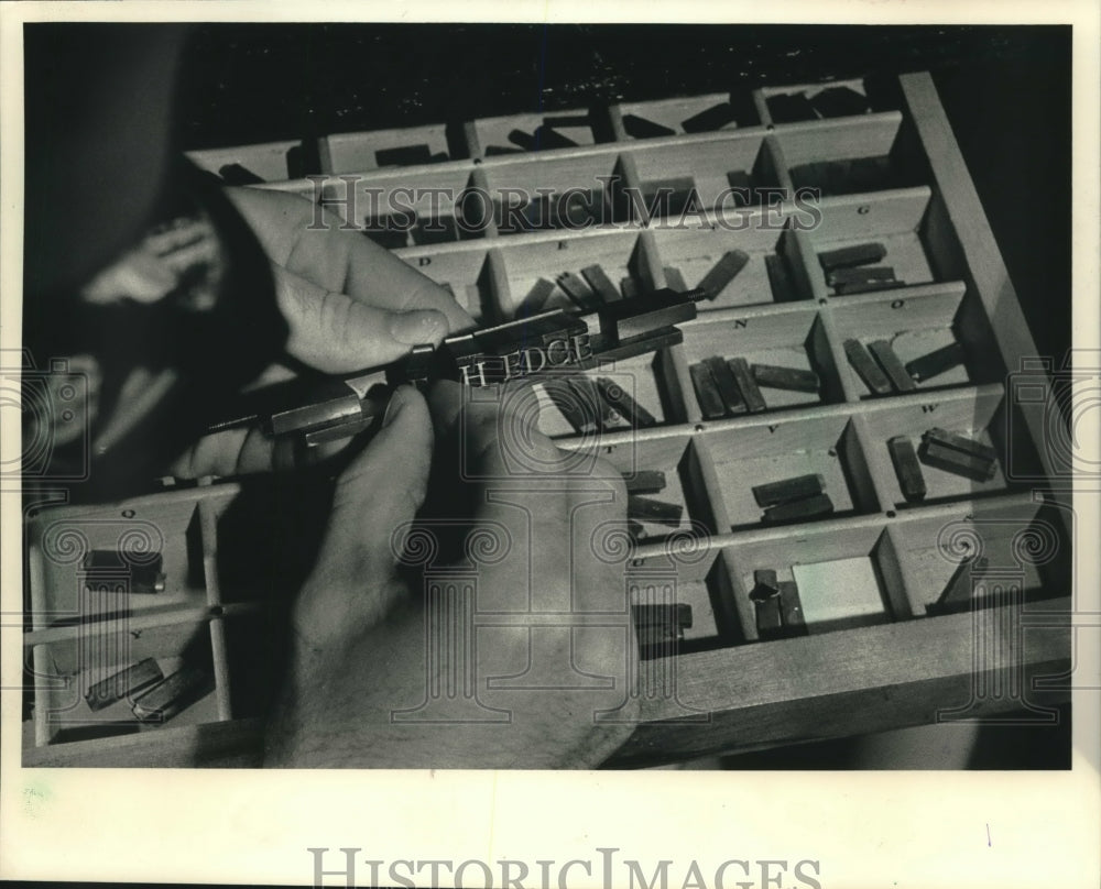 1986 Press Photo James Twomey hand-sets type for gold-stamping book titles - Historic Images