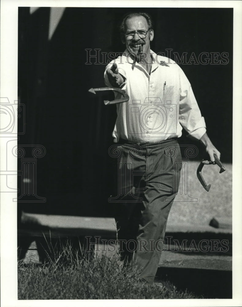 1990, Ollie Olson, of Oregon, pitches horseshoes during a work break - Historic Images