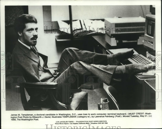 1988, James N. Templeman uses his toes to operate a computer keyboard - Historic Images