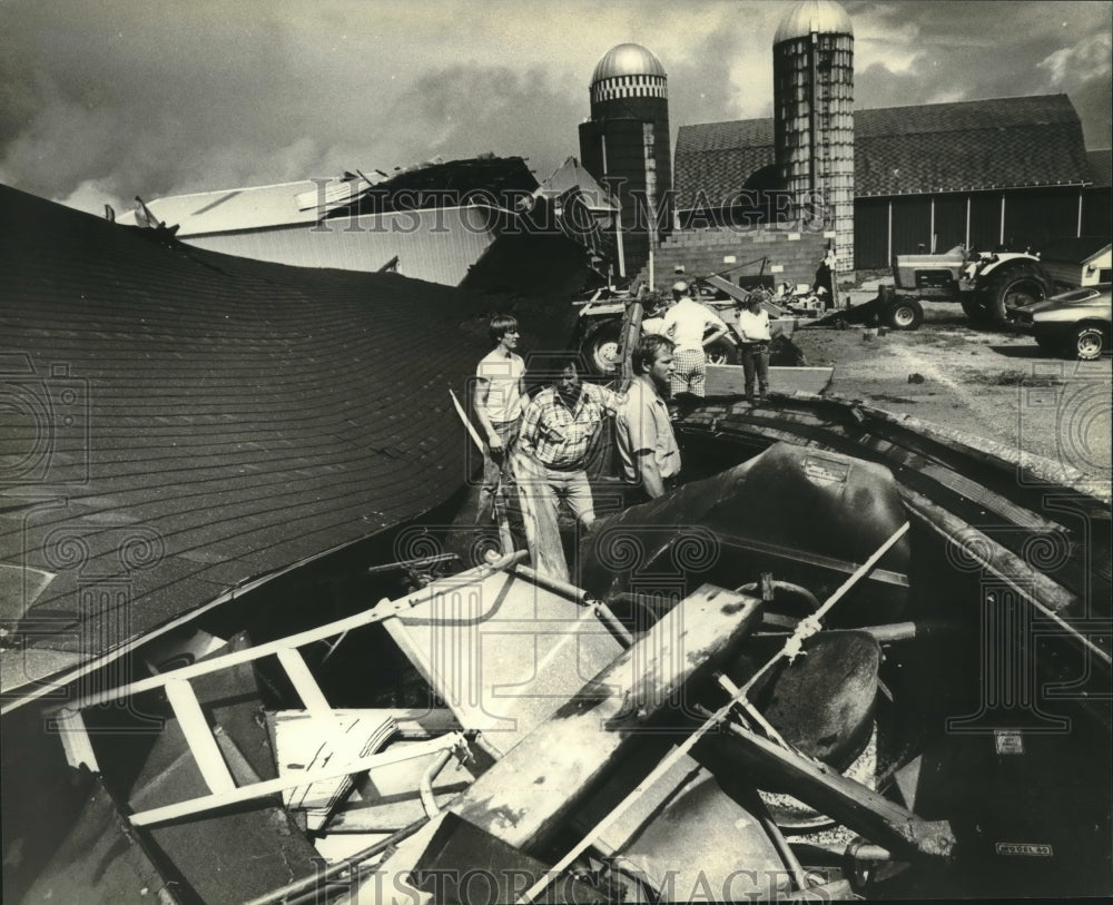 1981, Men surrounded by rubble left by storm in Burnett, Wisconsin - Historic Images