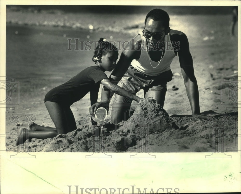 1986, Nesbitt Maclin built a sand castle with his daughter, Aneesha - Historic Images