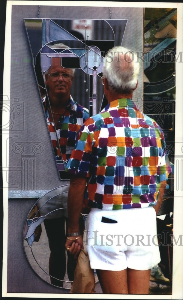 1993 Cardinal Stritch College &quot;Mile of Art&quot; fair-goer checks out art - Historic Images