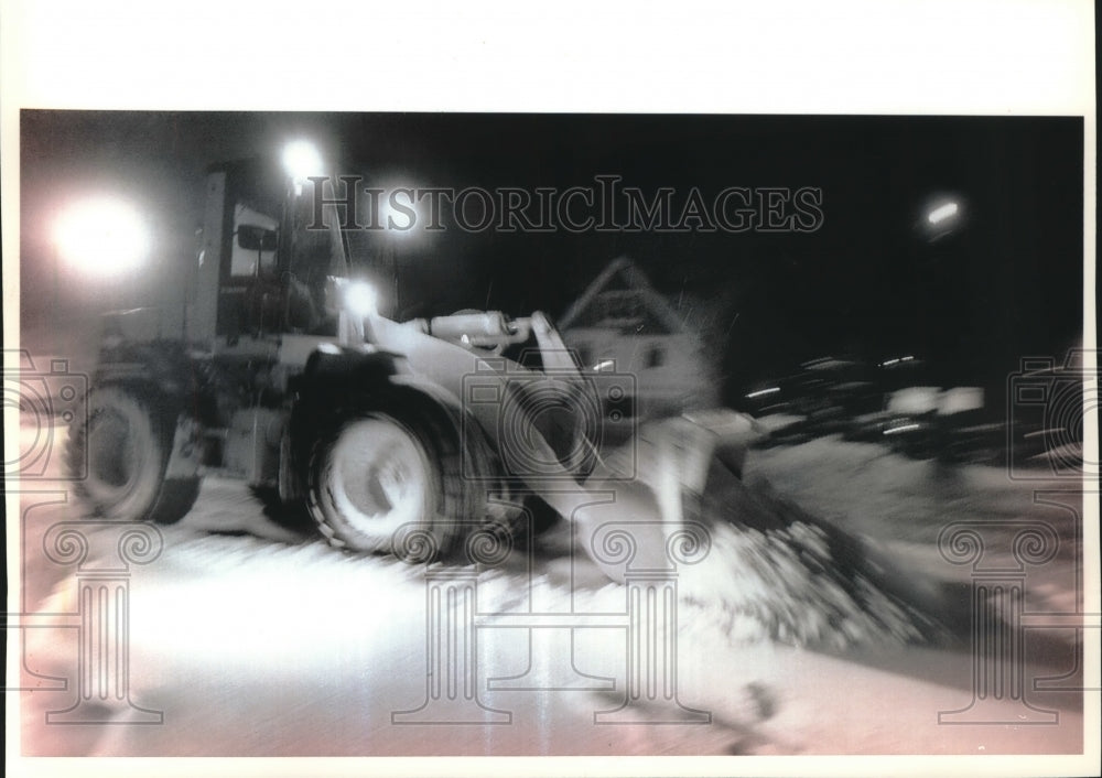 1994 Front-end loader shoveling snow off car parking lot,Thiensville - Historic Images