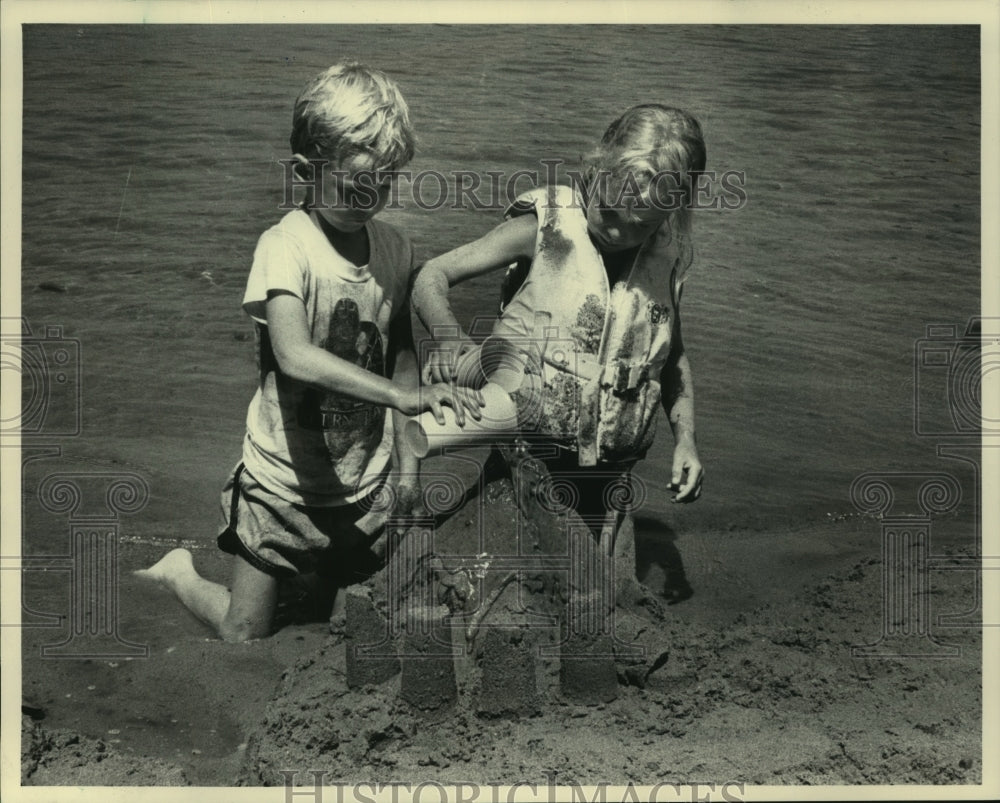 1983 Press Photo Dan and Sara Maki, make mud, sand, water castle, Moon Lake - Historic Images