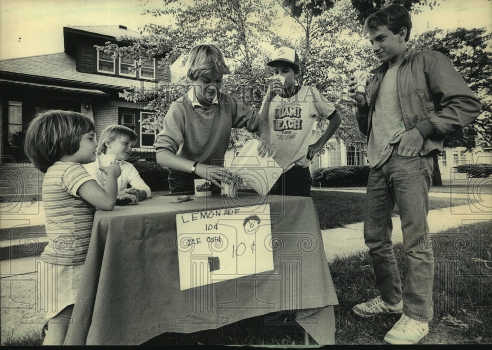1983 Nora Buckley serves other children at her lemonade stand - Historic Images