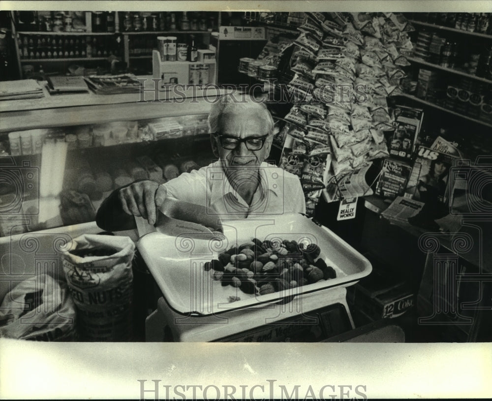 1980, Agamemnon Topitzes weighs nuts, grocery store, Milwaukee - Historic Images