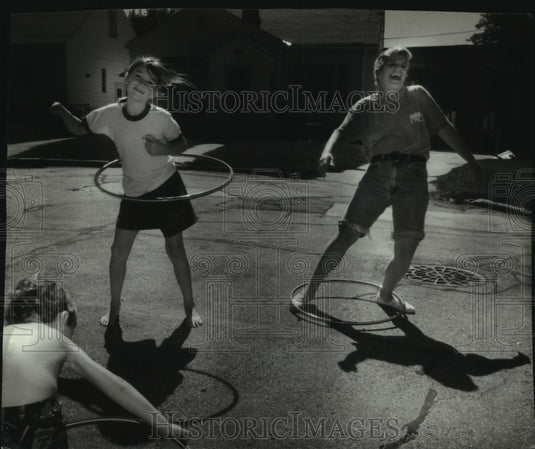 1994, Two young girls and a 4 year old boy hula hoop in Milwaukee. - Historic Images