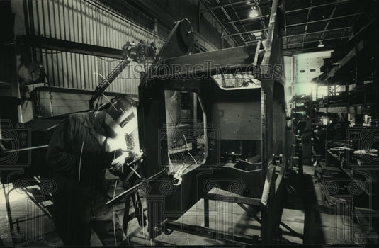 1988, John Johnson welds Sky Trak International ammunition handler - Historic Images